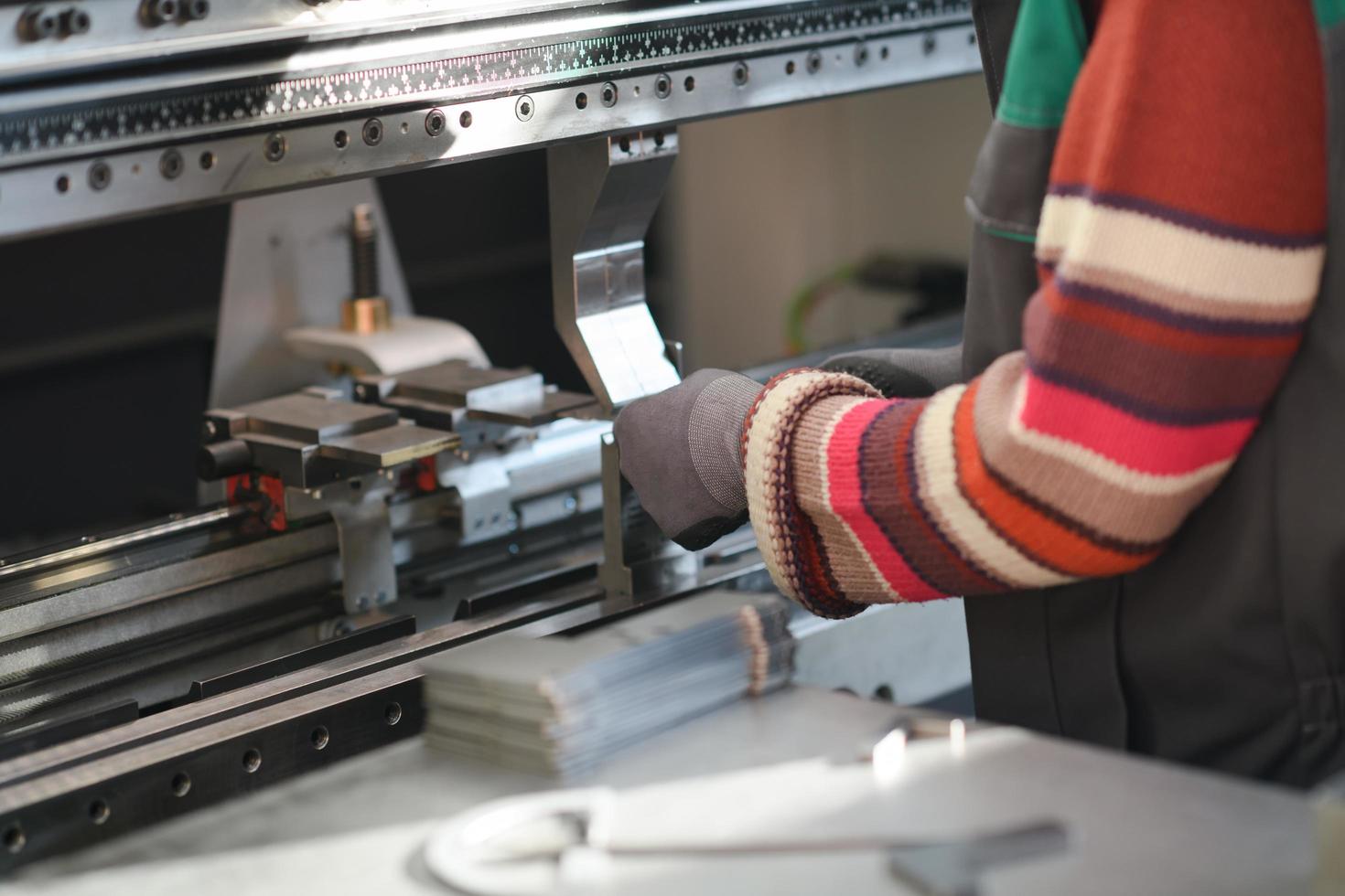 cierre la mano de una mujer trabajando en una fábrica moderna y preparando materia para una máquina cnc. foto