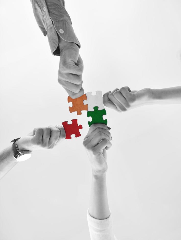 Group of business people assembling jigsaw puzzle photo