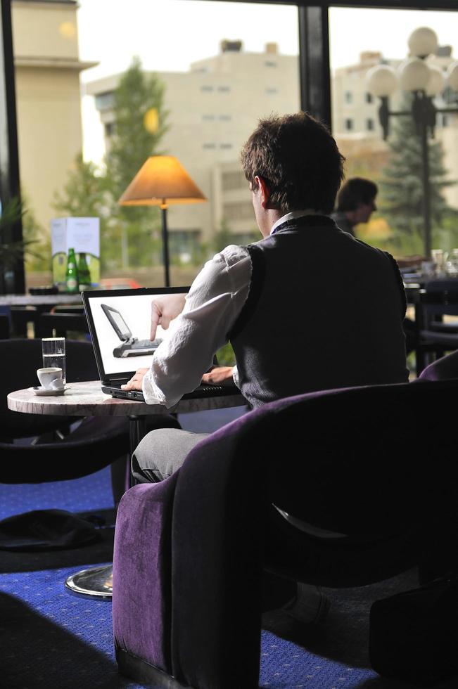 Happy man sitting and working on laptop photo