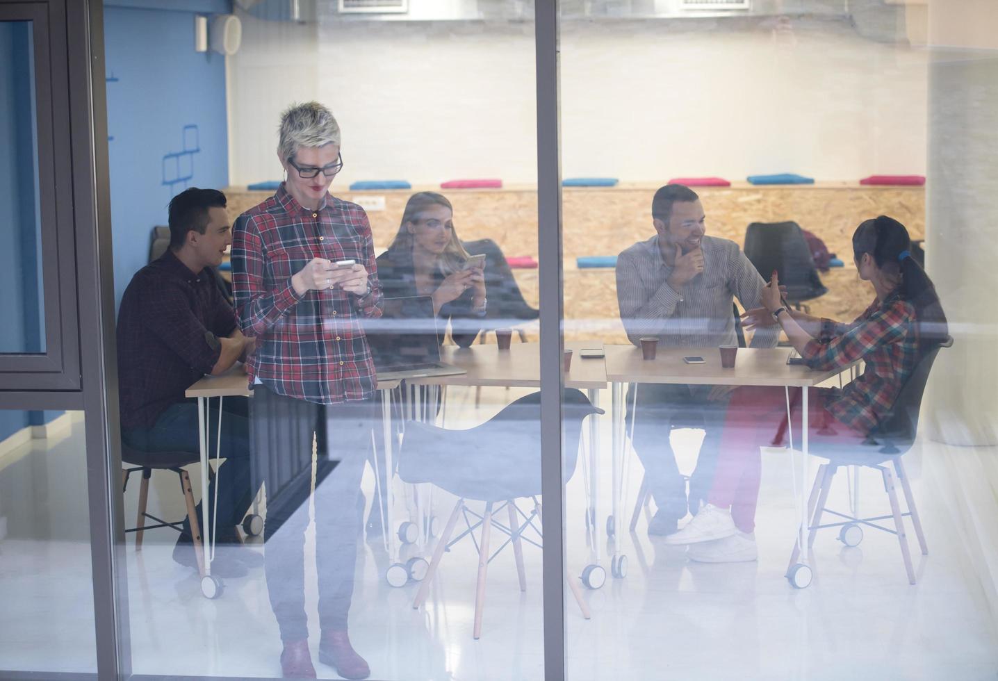 business woman at office speaking by phone  team on meeting in background photo