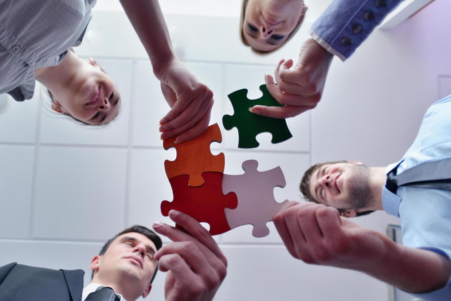 Group of business people assembling jigsaw puzzle photo