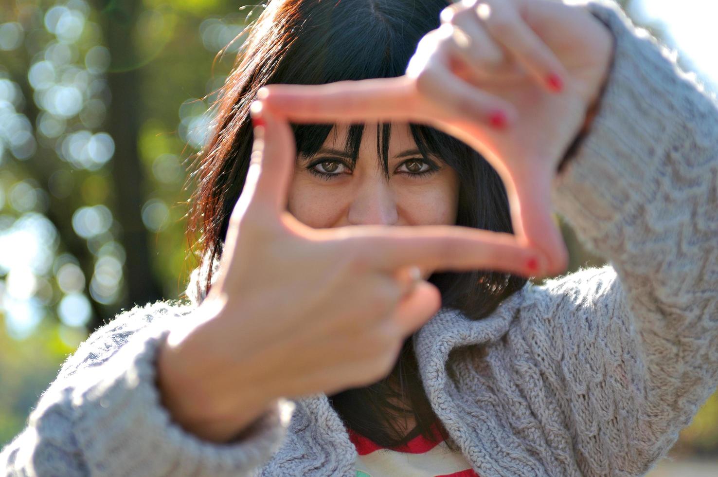 mujer joven que finge ver a través de una lente foto