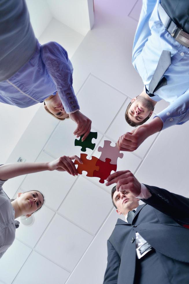 Group of business people assembling jigsaw puzzle photo