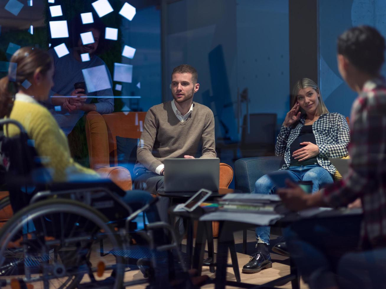Businesswoman in wheelchair having business meeting with team at modern office photo