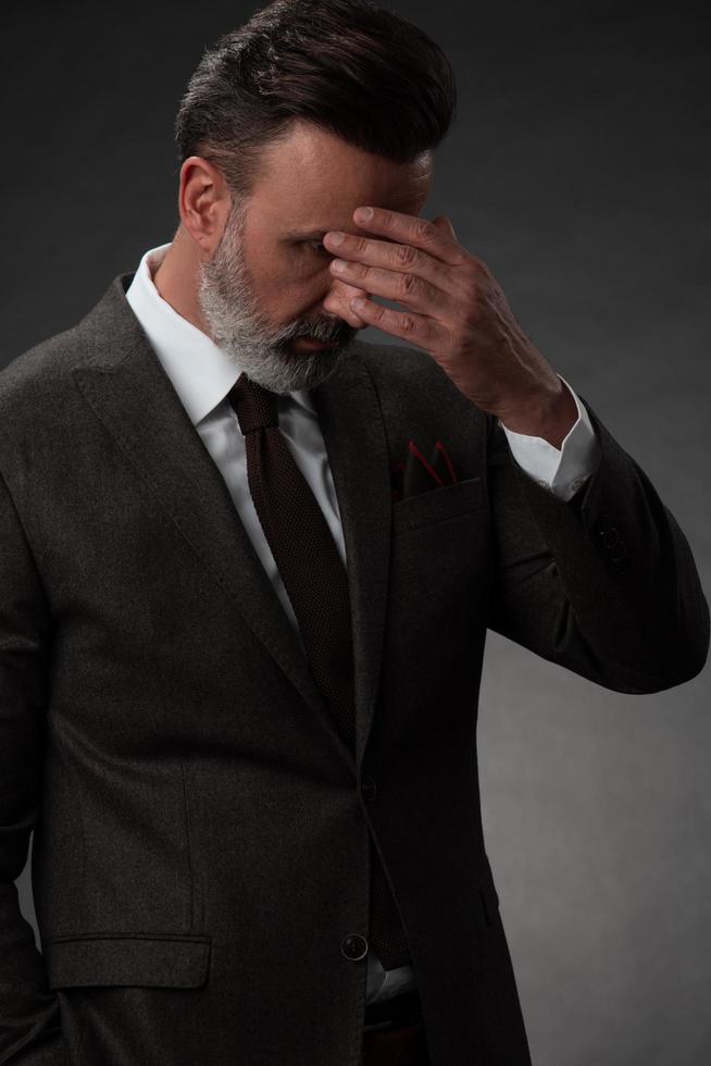 Frustrated middle aged elegant man Close up face of stressed businessman wearing stylish suit with eyes closed. Overworked middle eastern business man with terrible migrain photo