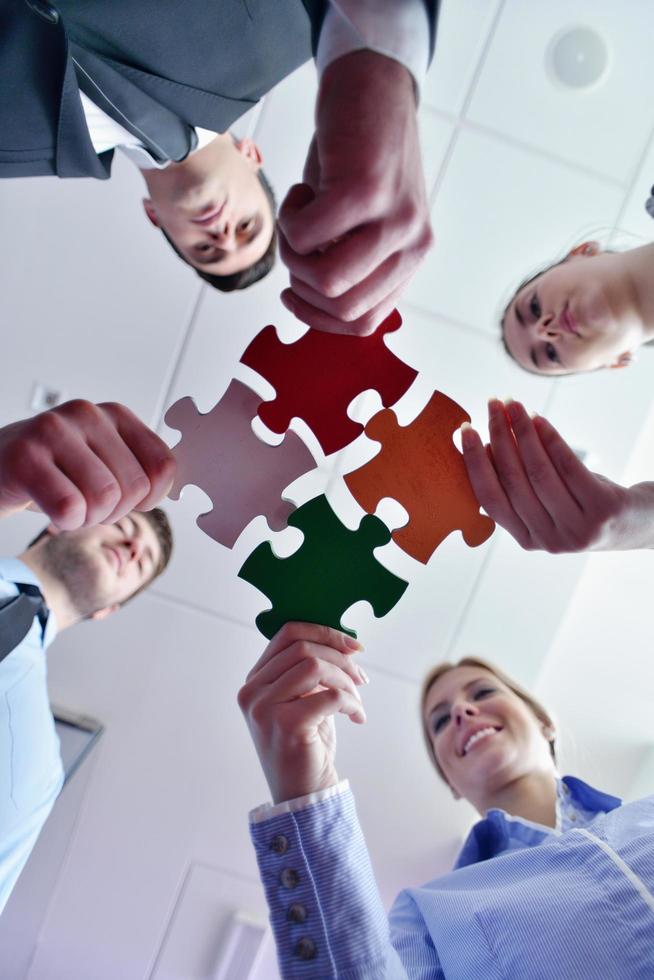 Group of business people assembling jigsaw puzzle photo