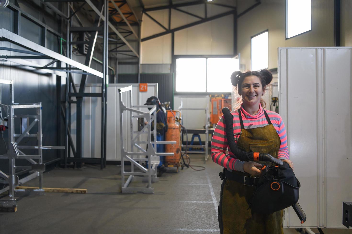 Turkey, 2022 - a portrait of a women welder holding a helmet and preparing for a working day in the metal industry photo