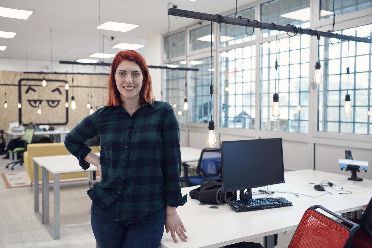 redhead woman at work  in creative modern coworking startup open space office photo