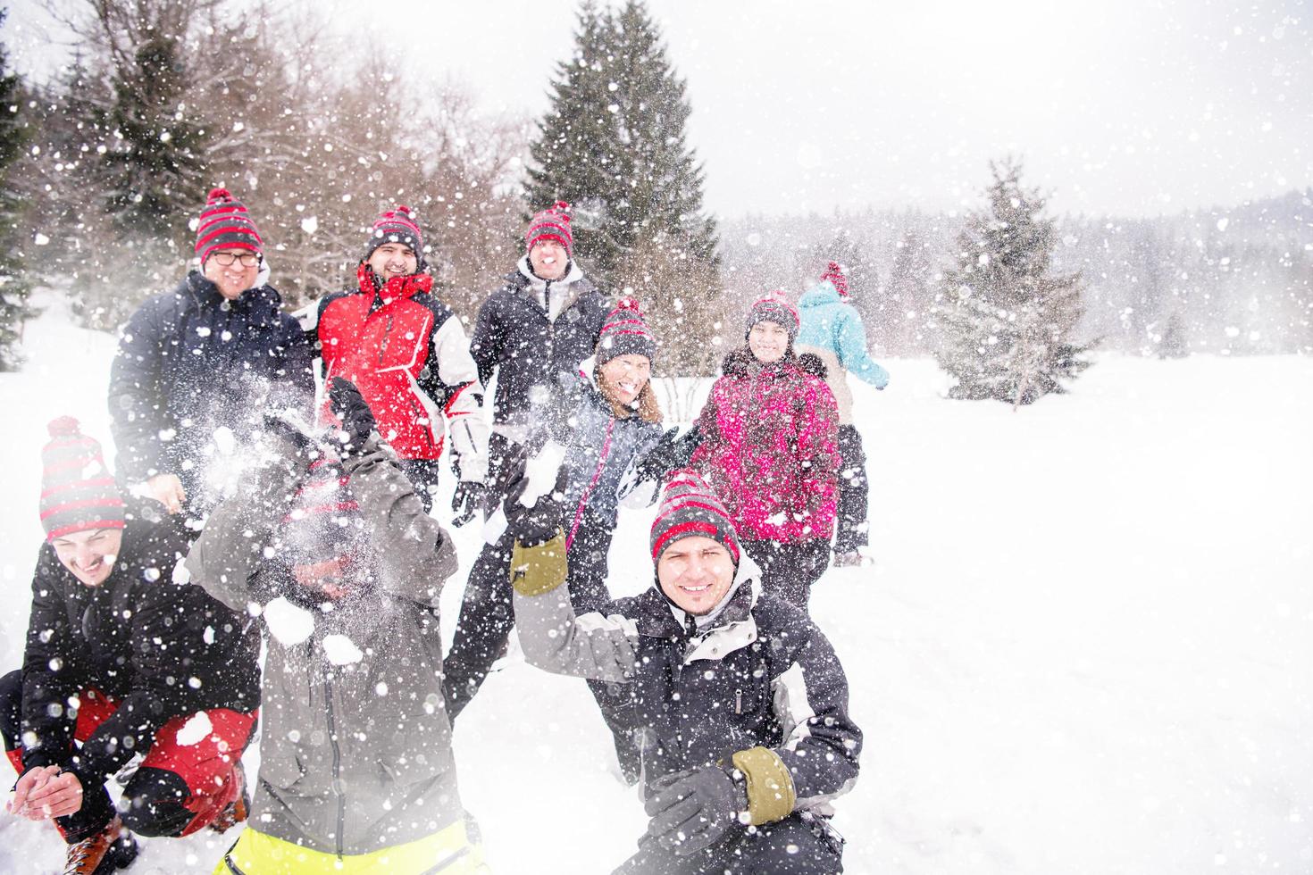 group of young people throwing snow in the air photo