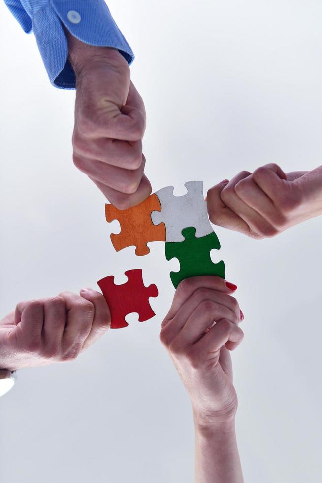 Group of business people assembling jigsaw puzzle photo