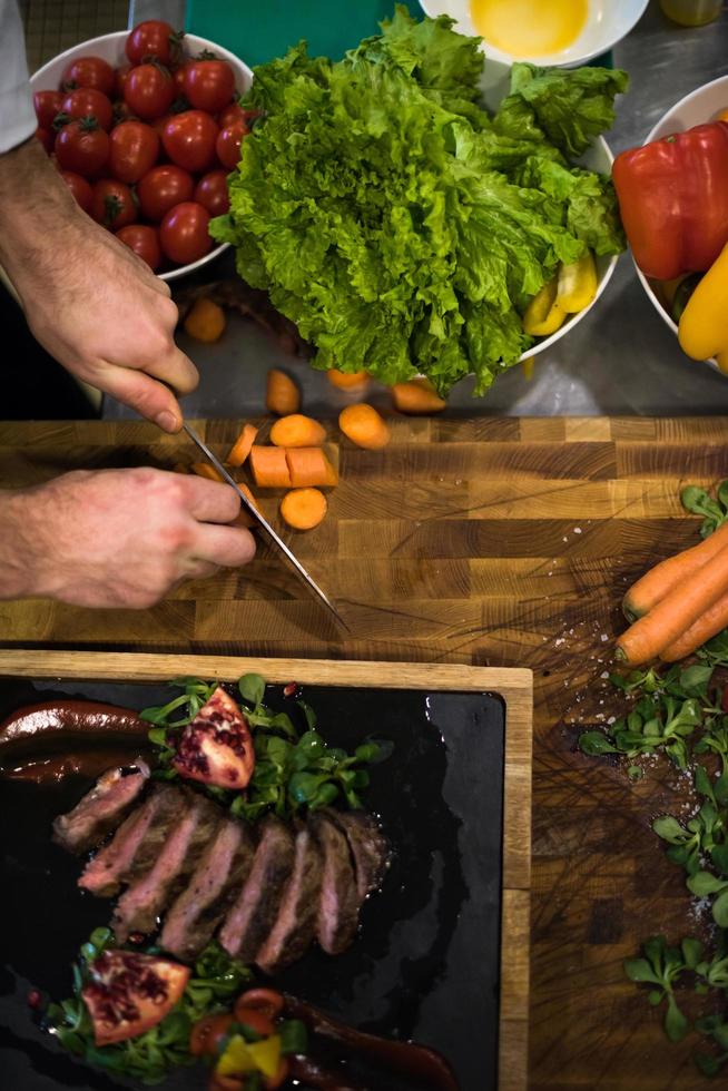 top view of Chef hands serving beef steak photo