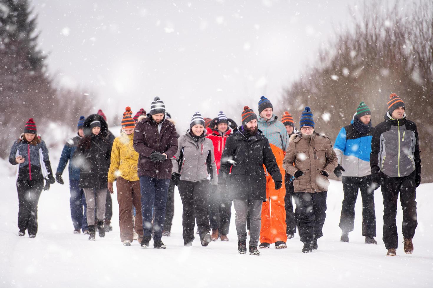 grupo de jóvenes caminando por un hermoso paisaje invernal foto