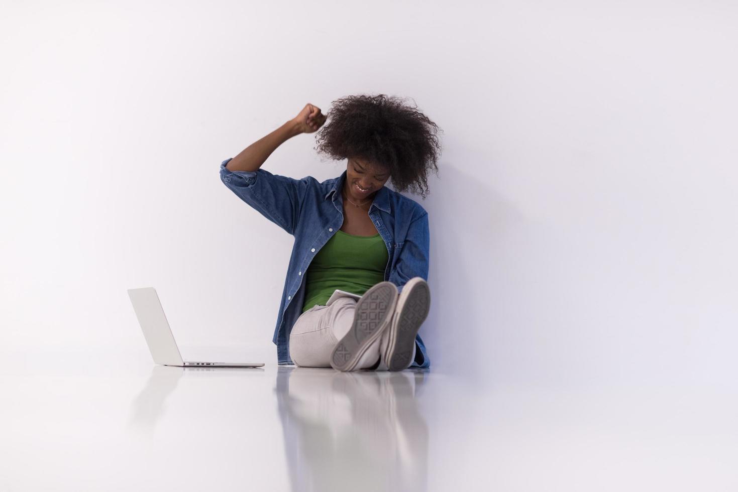 african american woman sitting on floor with laptop photo