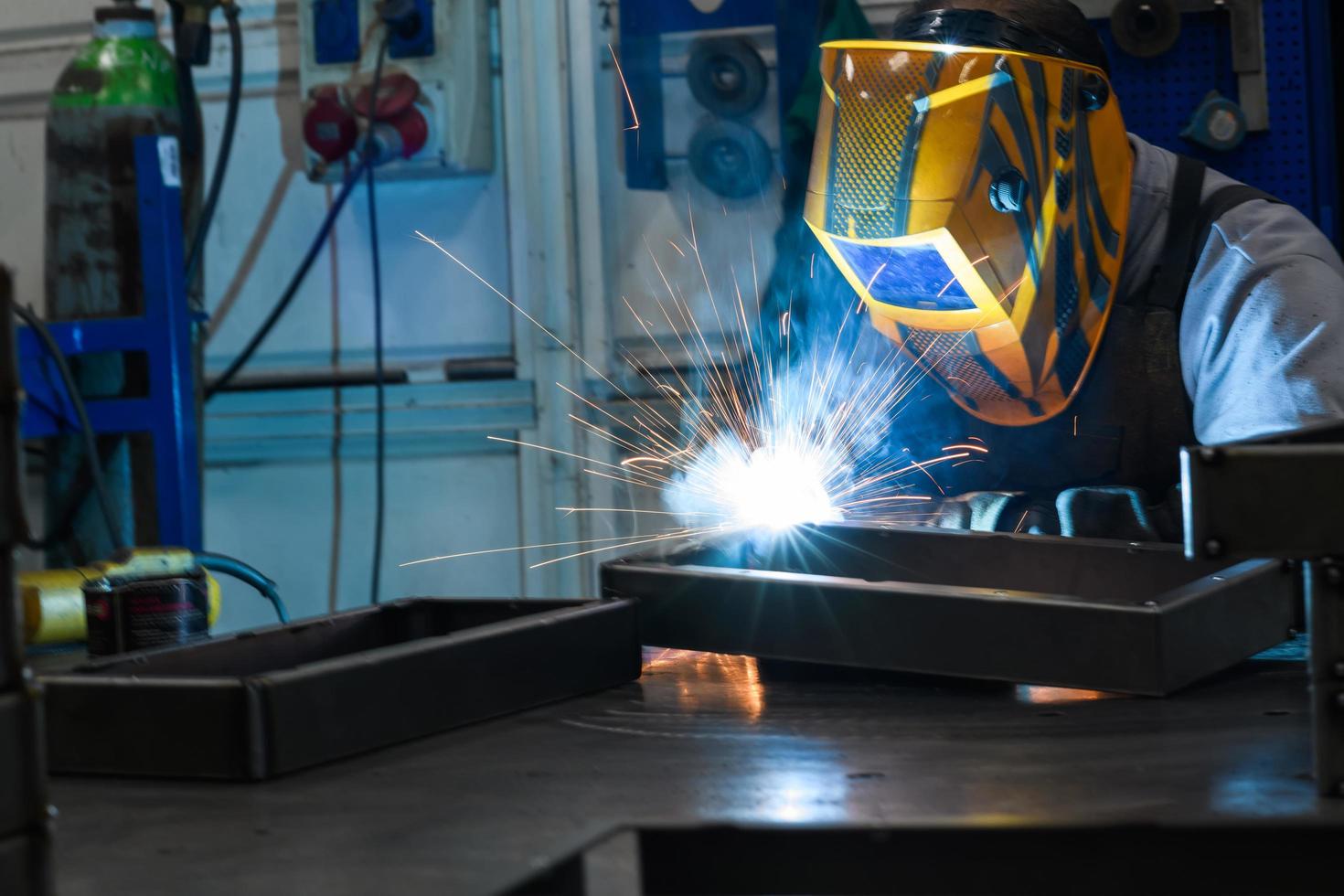 Professional welder performs work with metal parts in factory, sparks and electricity. Industry worker banner. photo