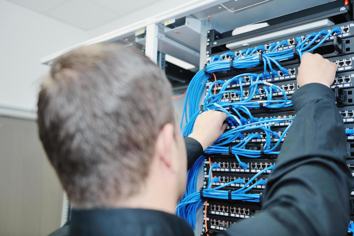 joven ingeniero informático en la sala de servidores del centro de datos foto