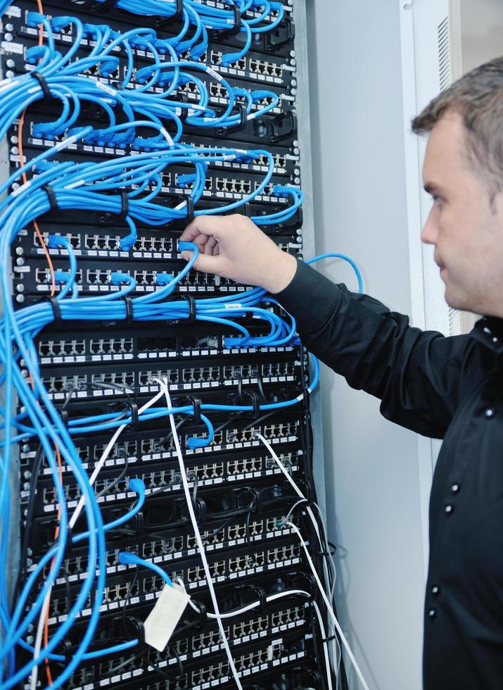 joven ingeniero informático en la sala de servidores del centro de datos foto