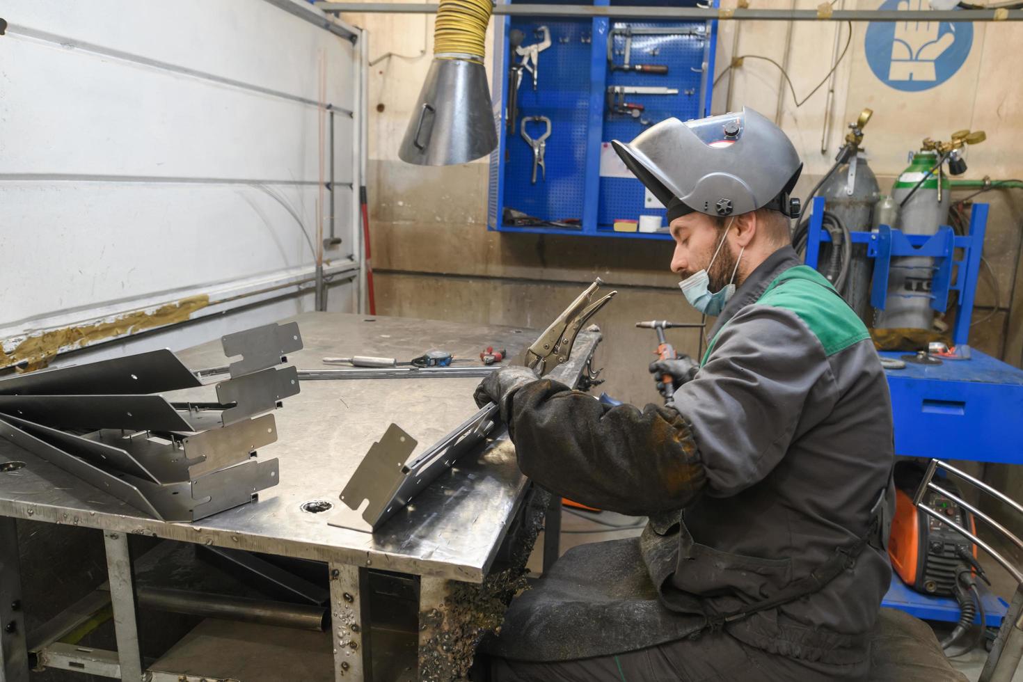 Metal industry worker working in factory, wearing protective face mask during coronavirus or covid19 pandemic. photo