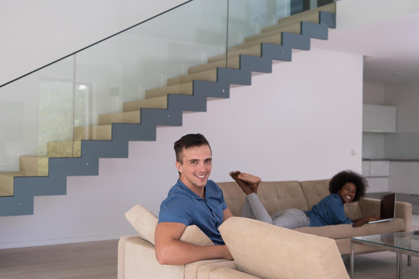 young multiethnic couple relaxes in the living room photo