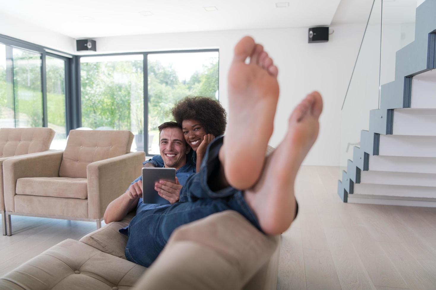 multiethnic couple relaxing at  home with tablet computers photo