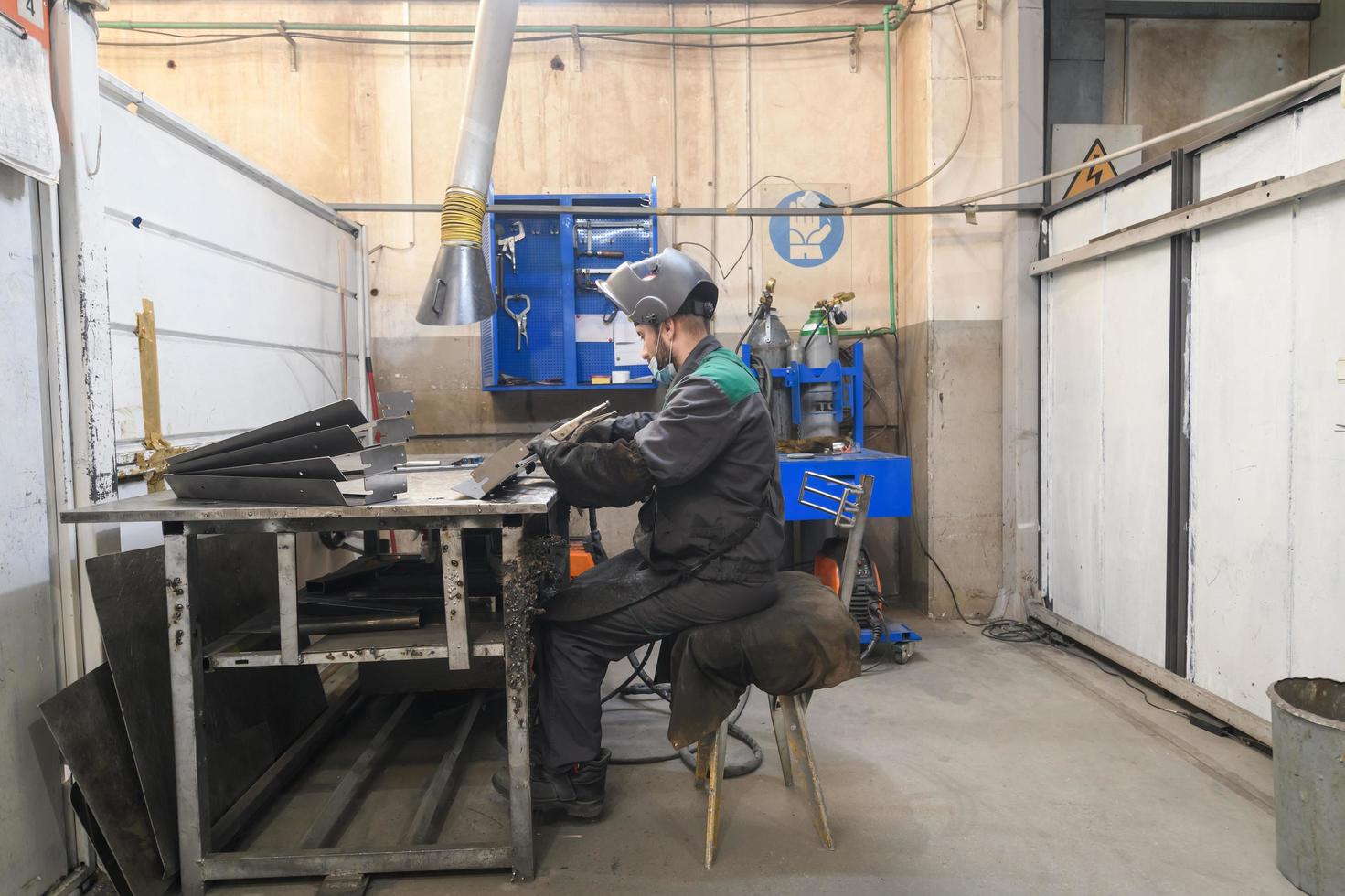 Metal industry worker working in factory, wearing protective face mask during coronavirus or covid19 pandemic. photo