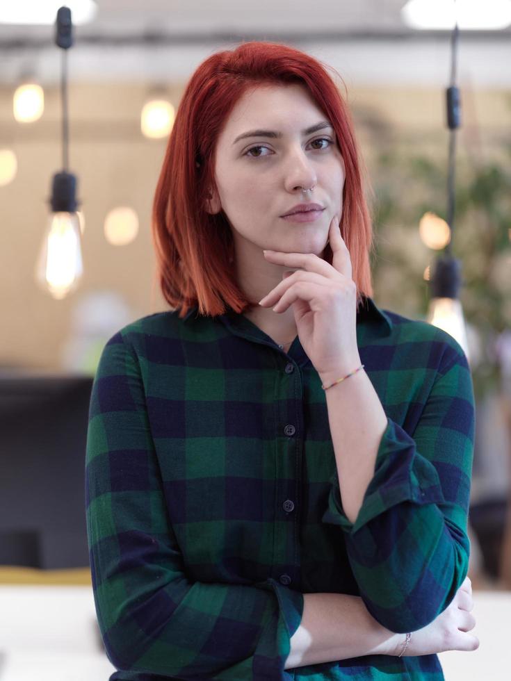redhead business woman portrait  in creative modern coworking startup open space office photo