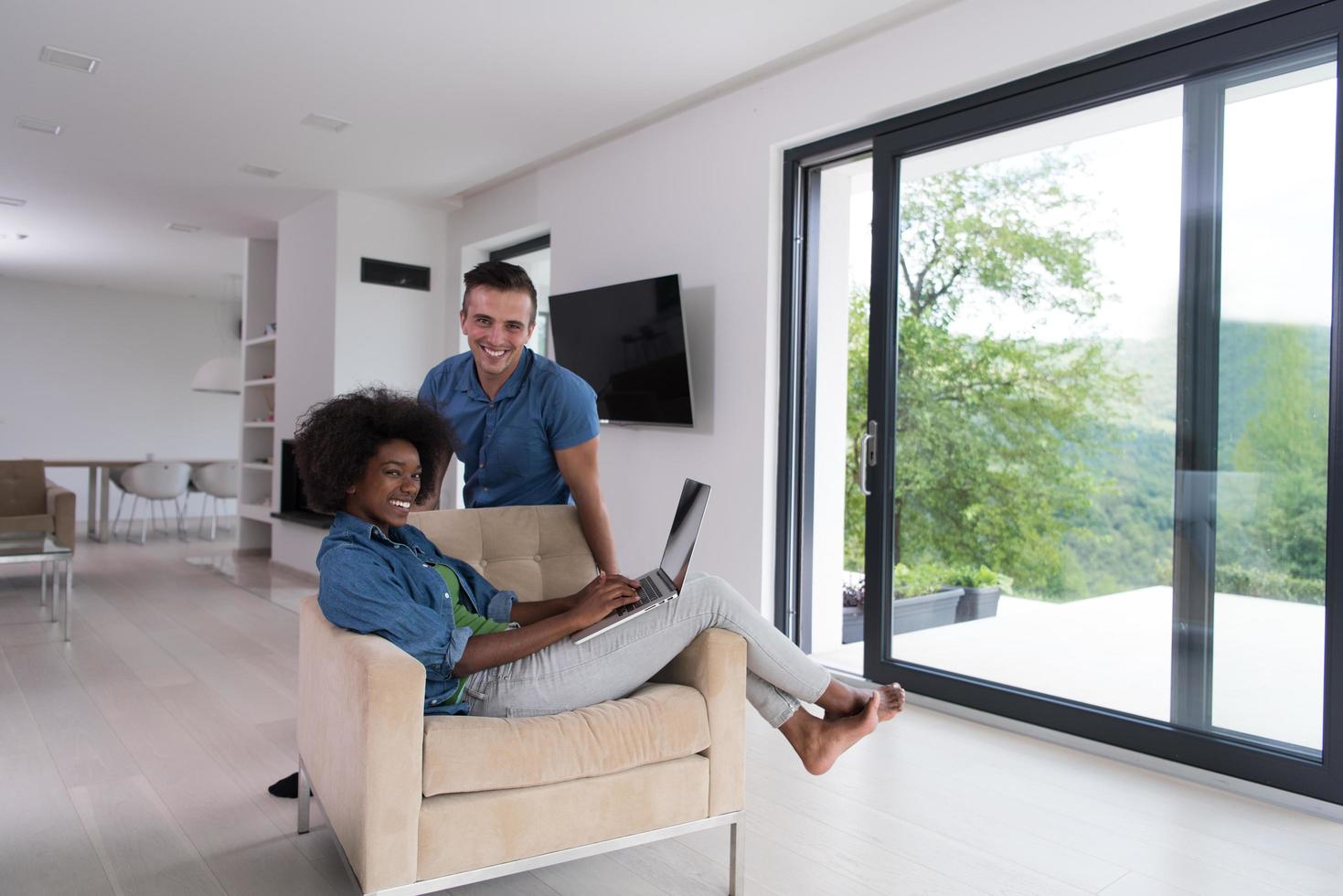 multiethnic couple on an armchair with a laptop photo