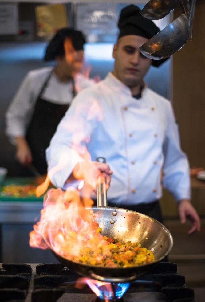 chef haciendo flambeado en la comida foto