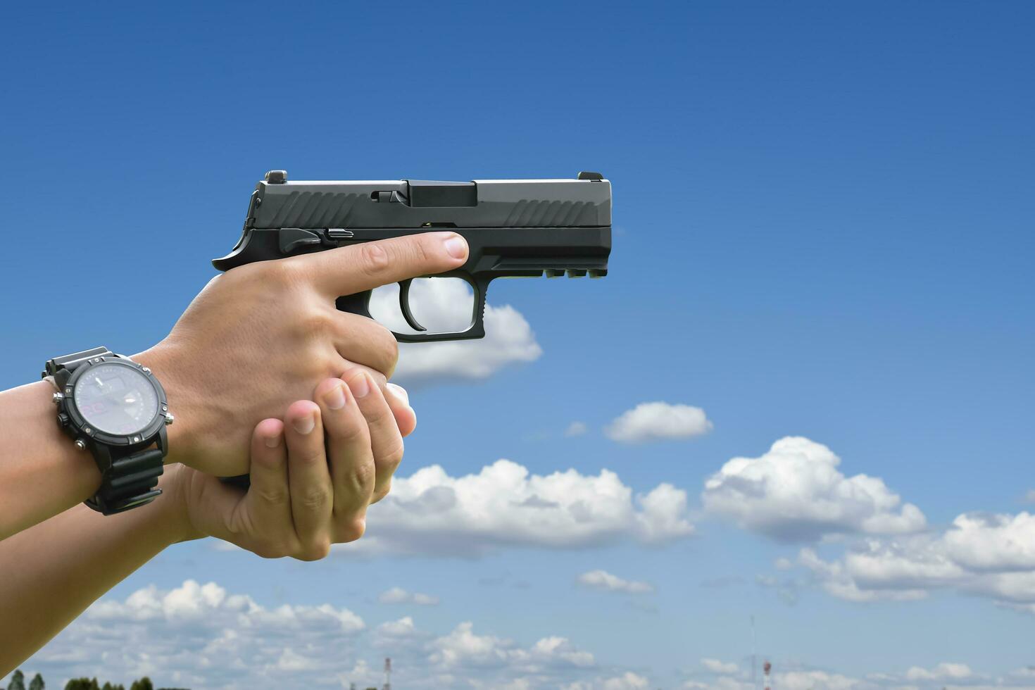 Pistol holding in hands of gunman at the shooting club, soft and selective focus on pistol, concept for shooting sport, bodyguard, security training, mafias, gangsters and self protections. photo