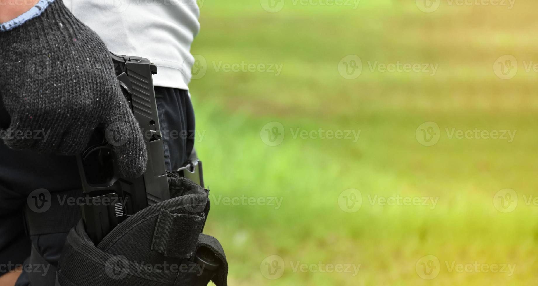 Pistol holding in hands of gunman at the shooting club, soft and selective focus on pistol, concept for shooting sport, bodyguard, security training, mafias, gangsters and self protections. photo