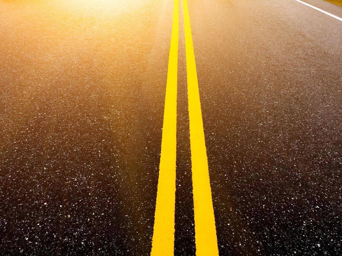 Asphalt road with yellow lines in the evening of the day with empty cars, soft and selective focus. photo