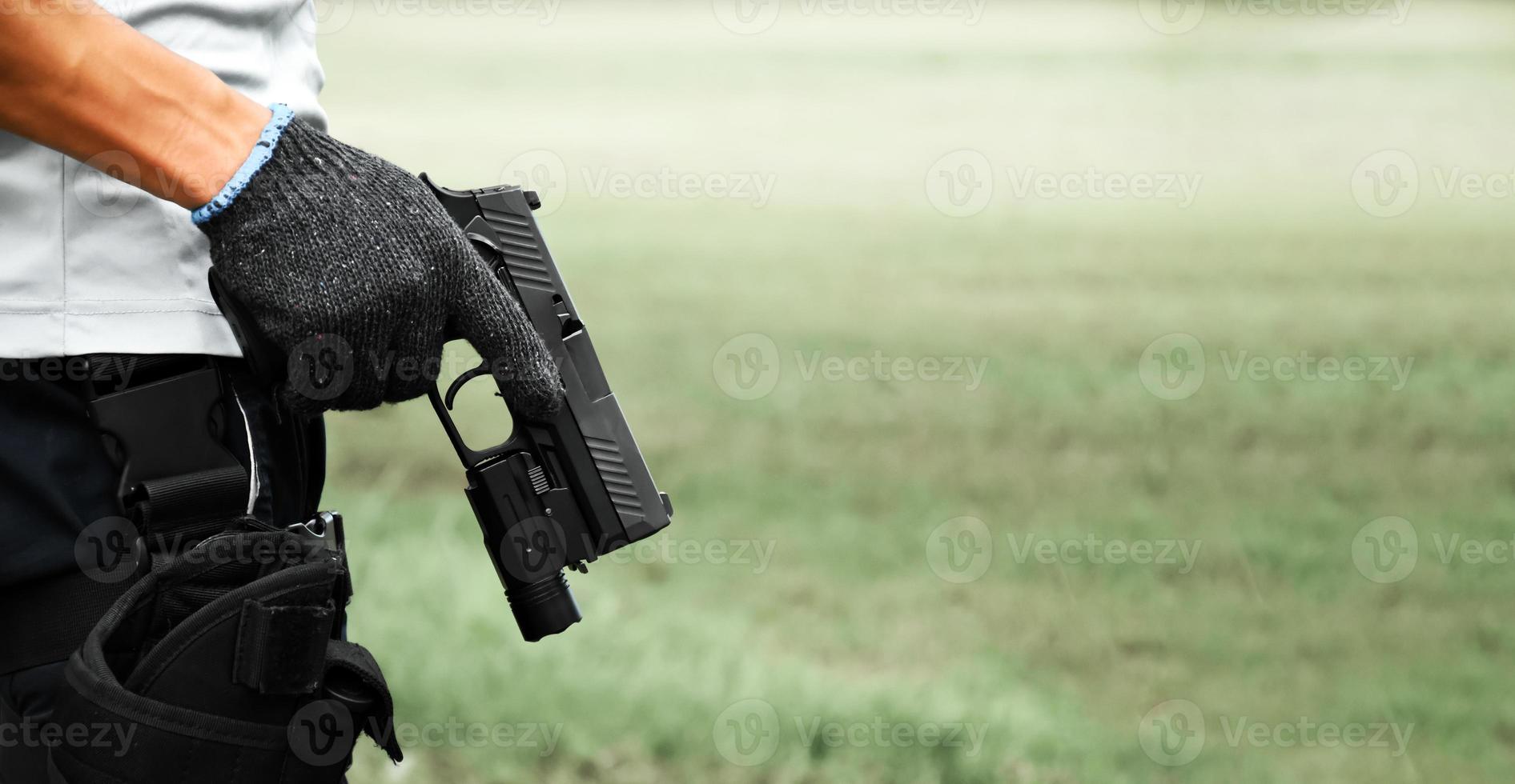 Pistol holding in hands of gunman at the shooting club, soft and selective focus on pistol, concept for shooting sport, bodyguard, security training, mafias, gangsters and self protections. photo