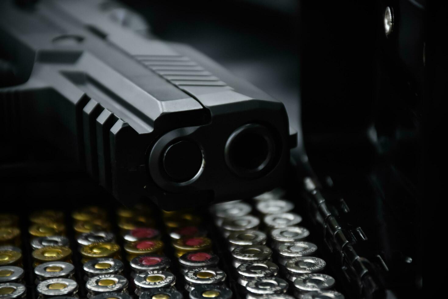 Automatic black 9mm pistol and bullets on black leather background, selective and soft focus. photo