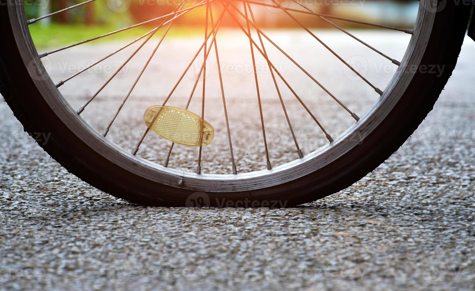 Closeup flat rear wheel of the bike which parked on pavement, soft and selective focus. photo