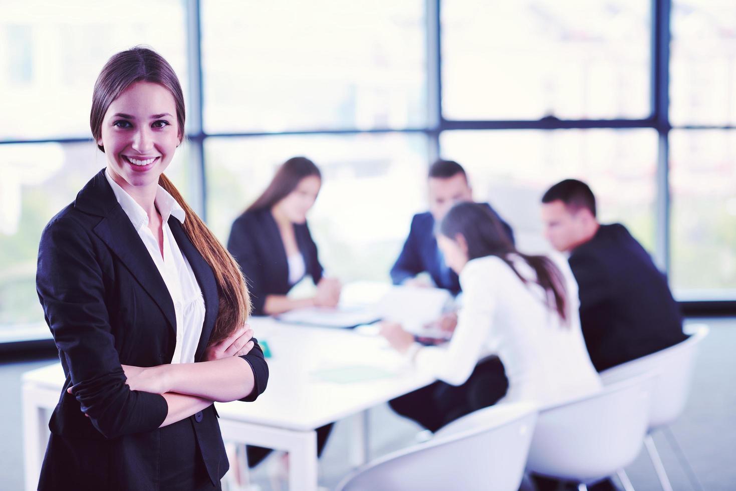 business woman with her staff in background at office photo