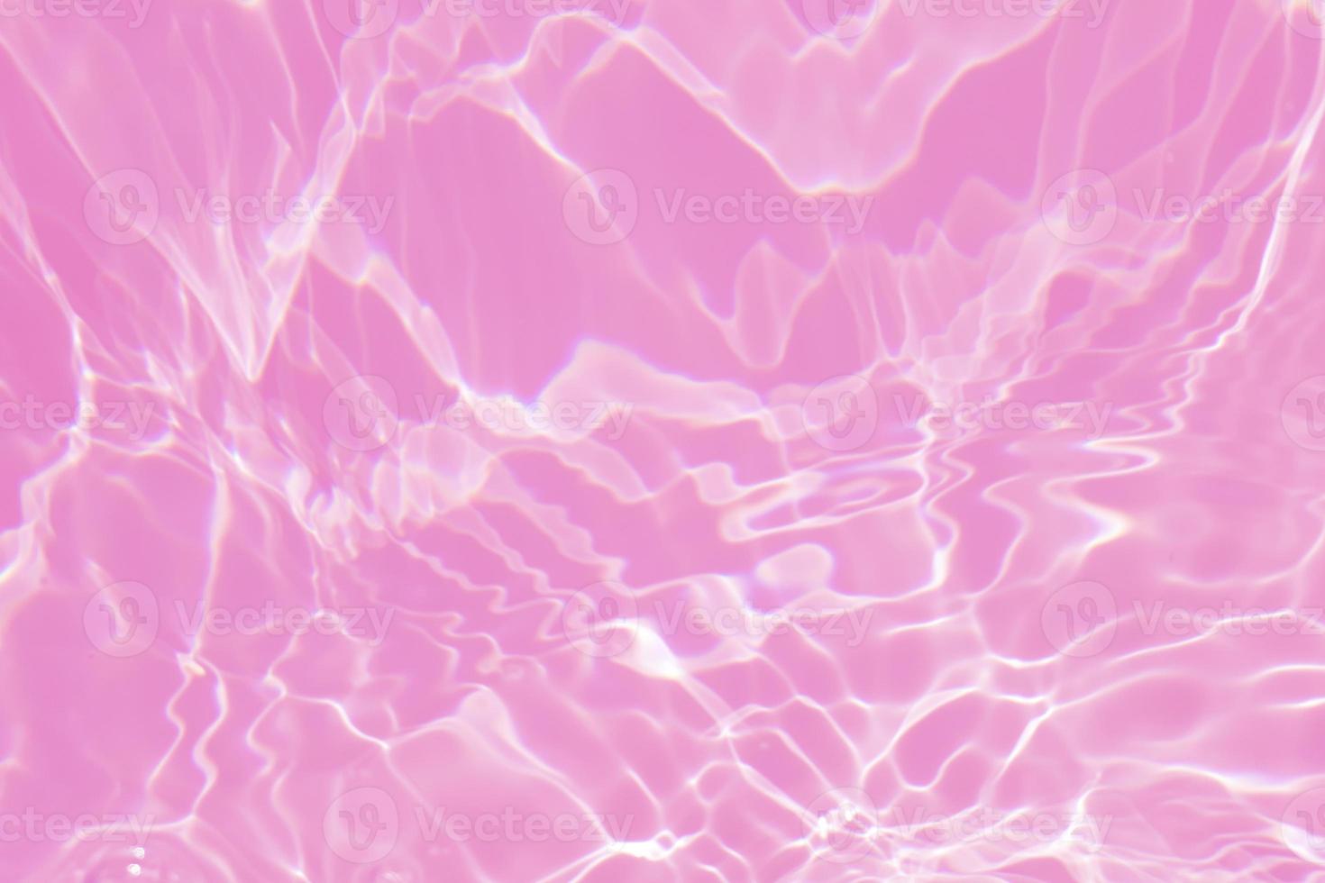 Defocus blurred transparent pink colored clear calm water surface texture with splash, bubble. Shining pink water ripple background. Surface of water in swimming pool. Tropical pink water color flow. photo