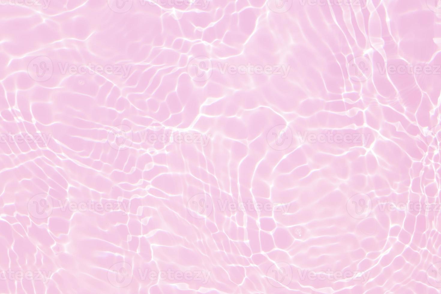 Defocus blurred transparent pink colored clear calm water surface texture with splash, bubble. Shining pink water ripple background. Surface of water in swimming pool. Tropical pink water color flow. photo