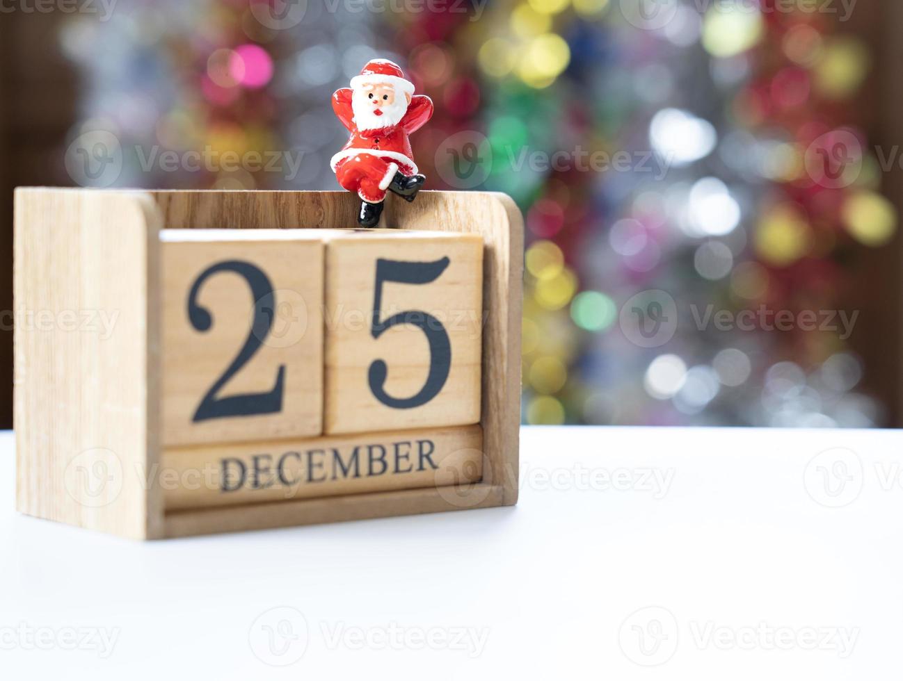 Santa Claus sitting on a block date 25 December in anticipation of the funny and happiness festival. photo