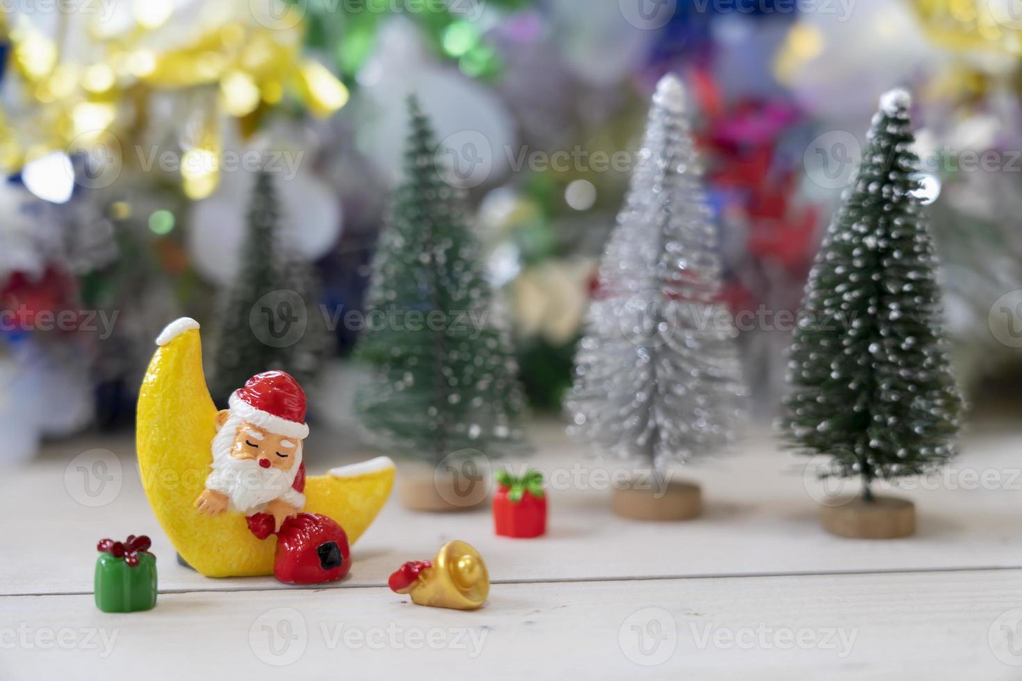 Santa sleep in the Croissant moon in front of Christmas trees waiting for funny festival Christmas and Happy New Year to created greeting card, happiness and funny concept. photo