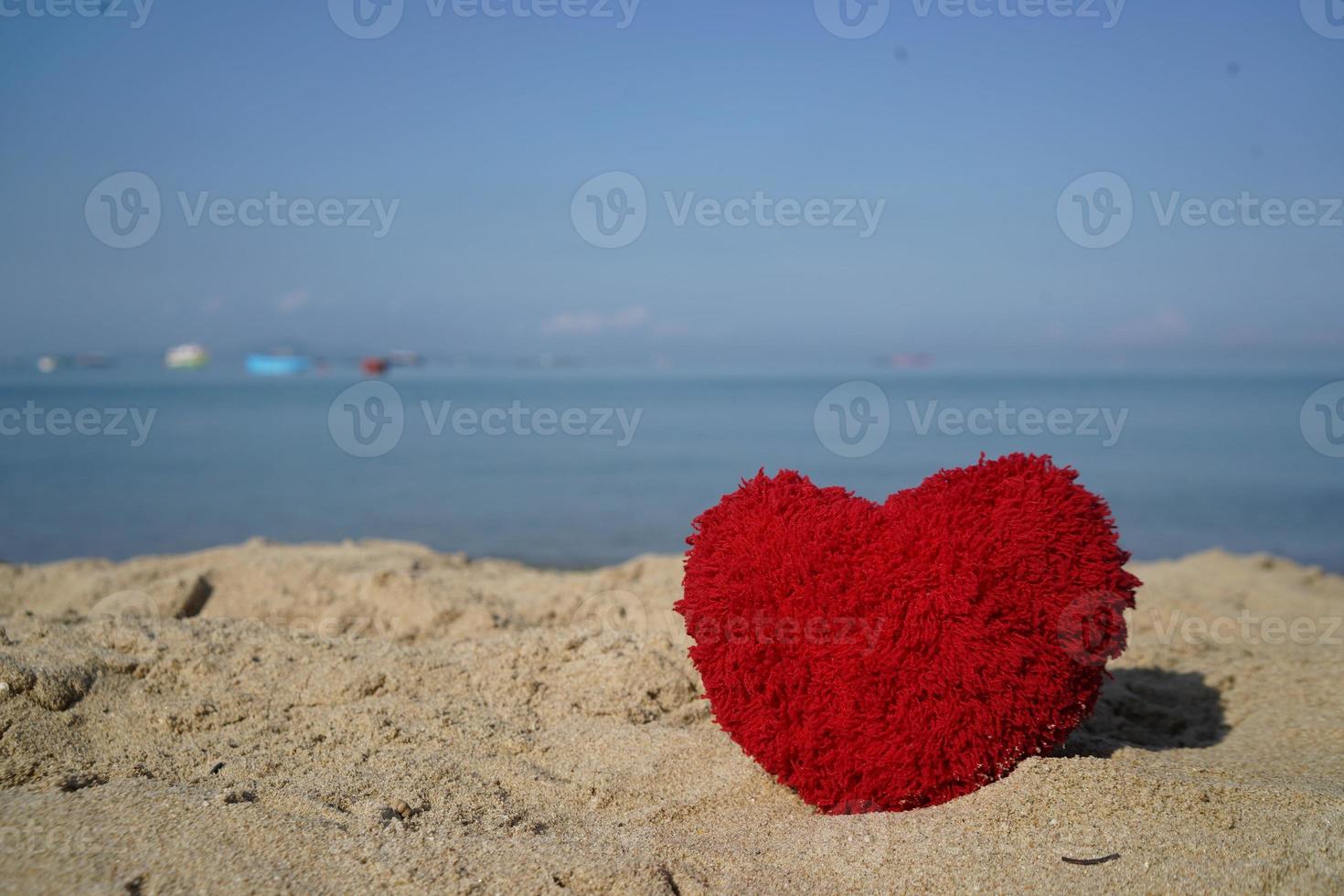 Red heart shape on sand beach at coast for create sweet lovely card and couple poster. photo