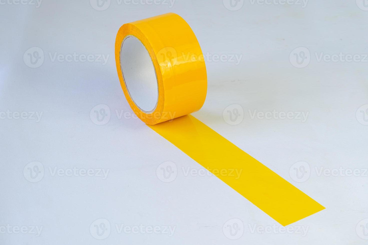 Rollo de cinta adhesiva amarilla sobre fondo aislado foto