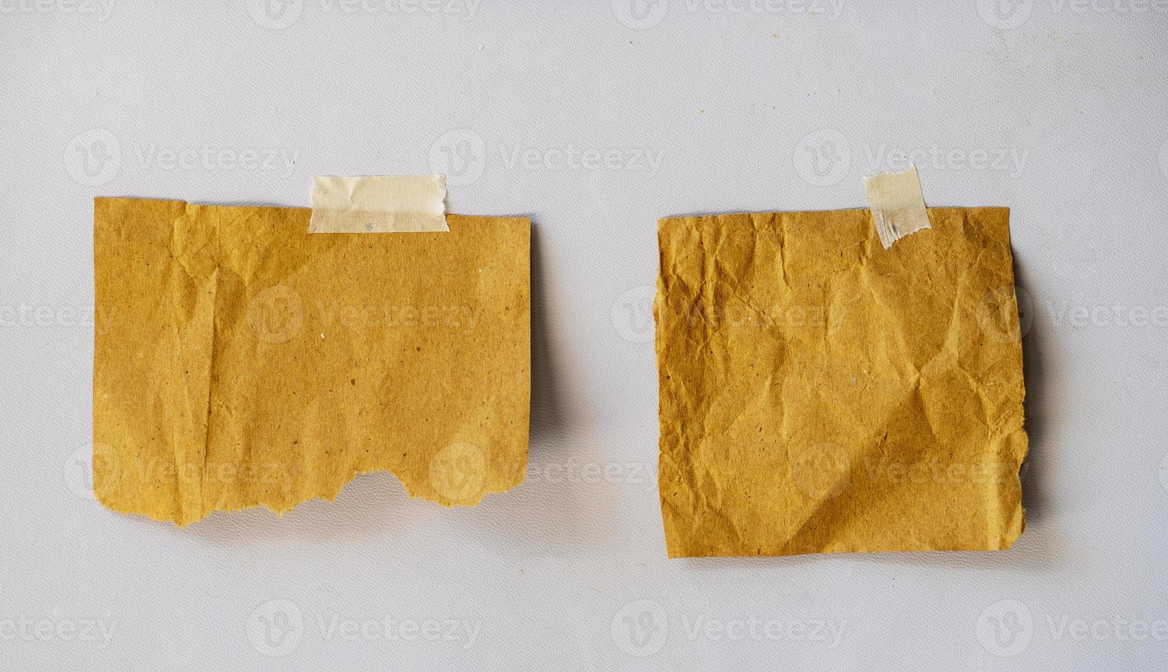blank sticky note paper for mockup. torn old paper glued with tape on the wall photo