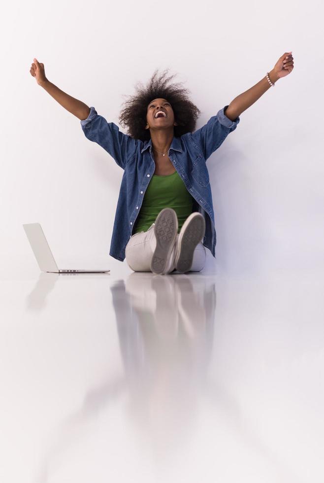 african american woman sitting on floor with laptop photo