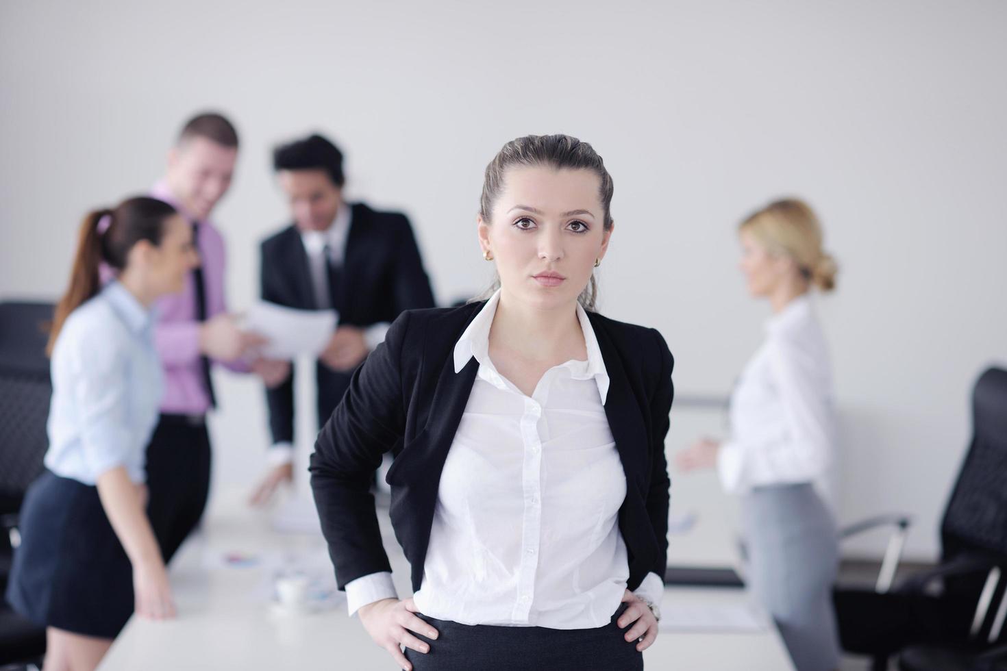 business woman standing with her staff in background photo