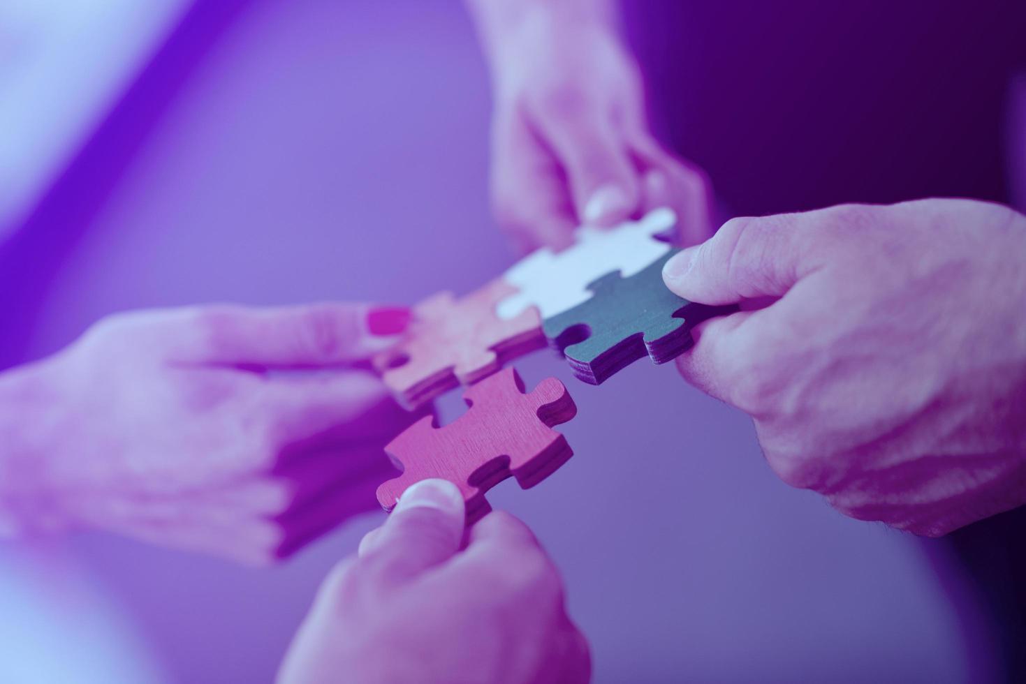 Group of business people assembling jigsaw puzzle photo