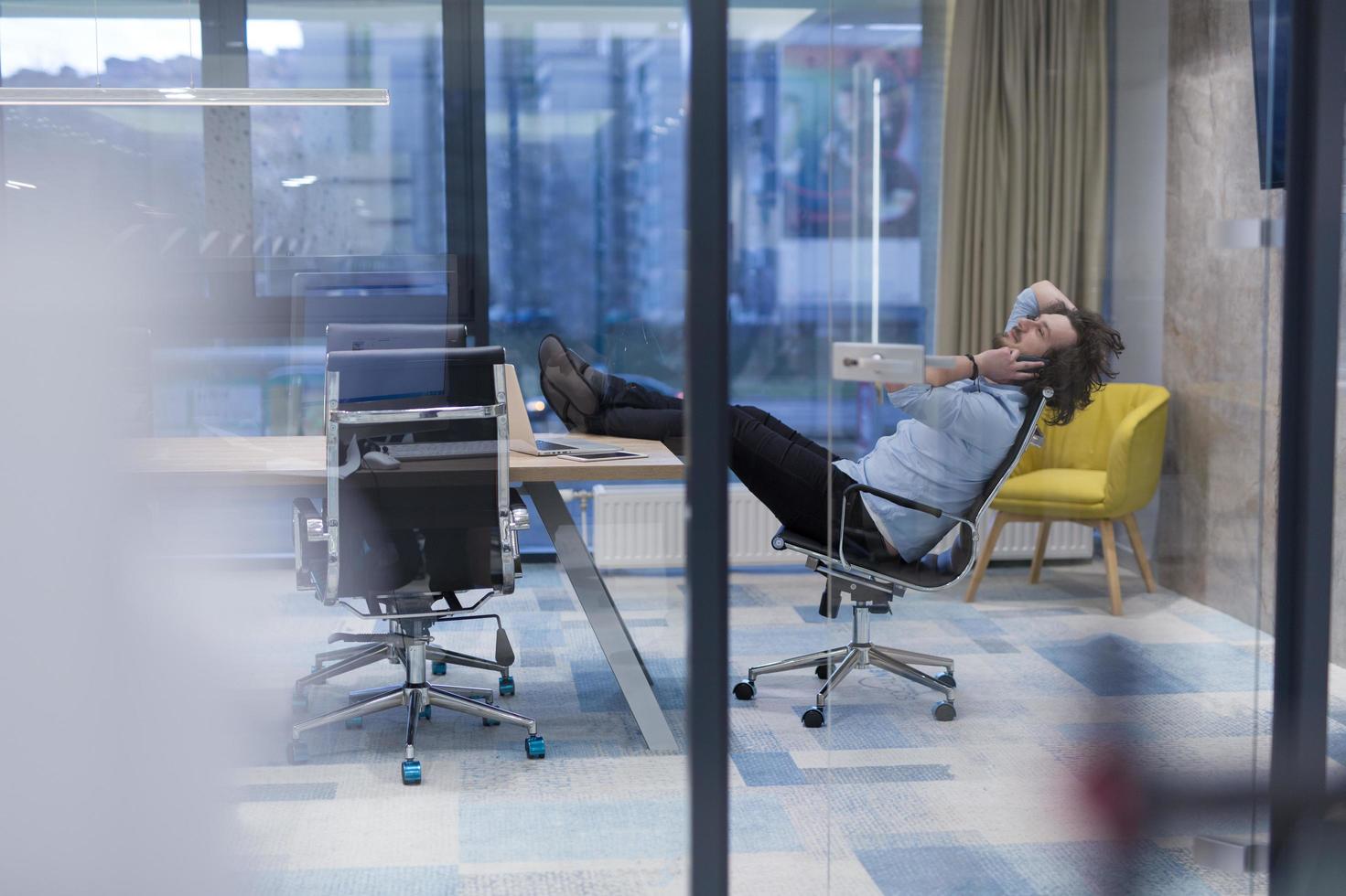 young businessman relaxing at the desk photo