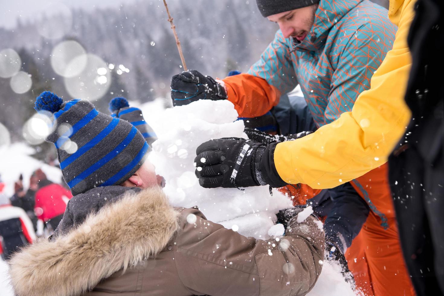 group of young people making a snowman photo