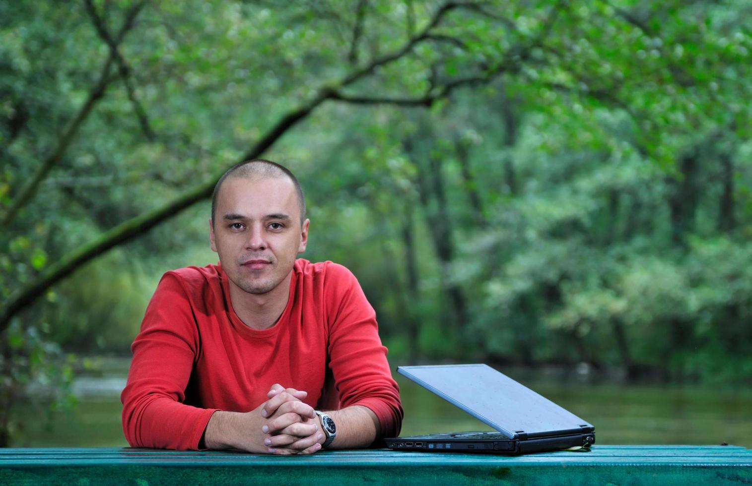 joven empresario trabajando al aire libre en la computadora portátil foto