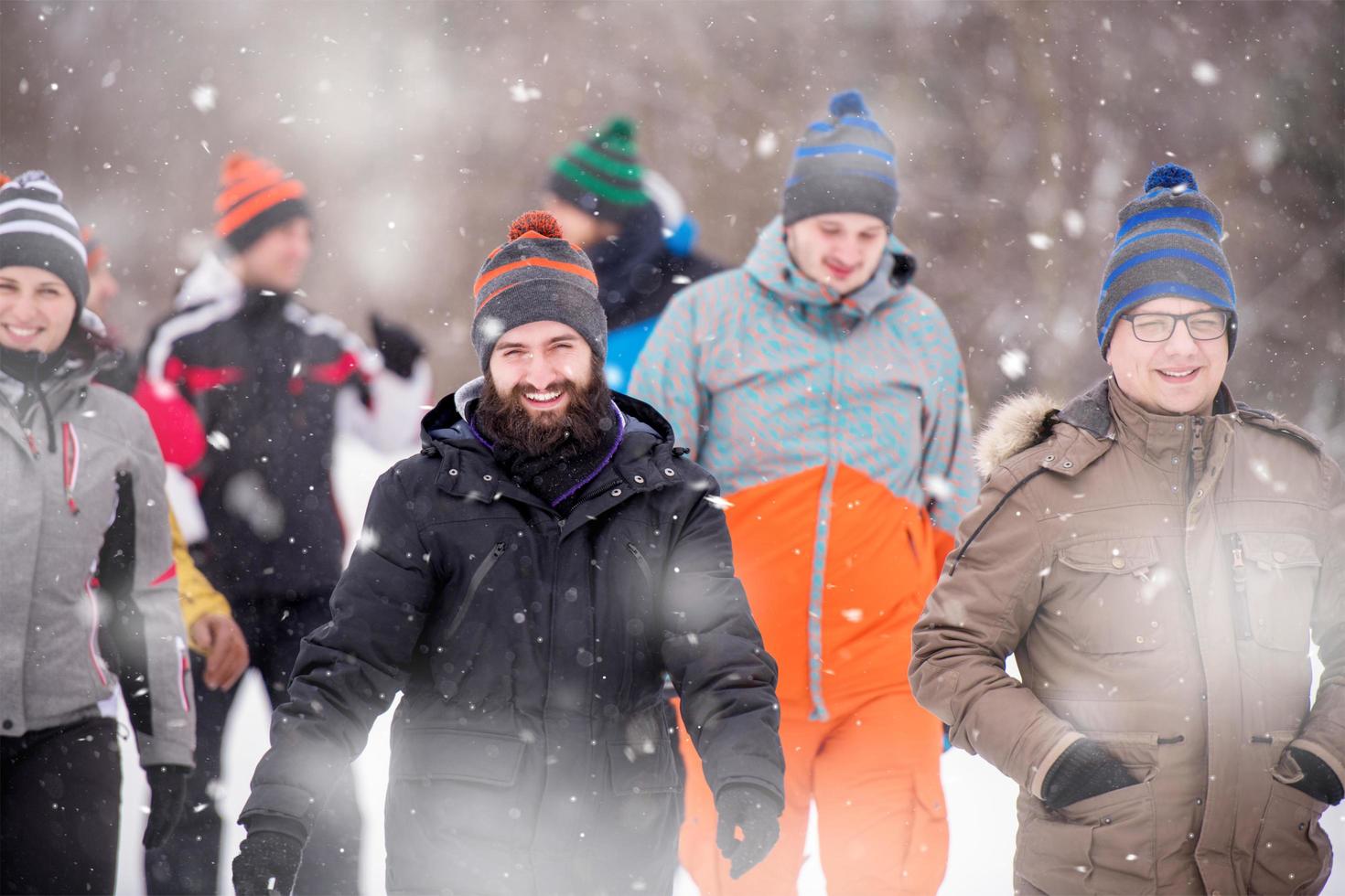 group of young people walking through beautiful winter landscape photo