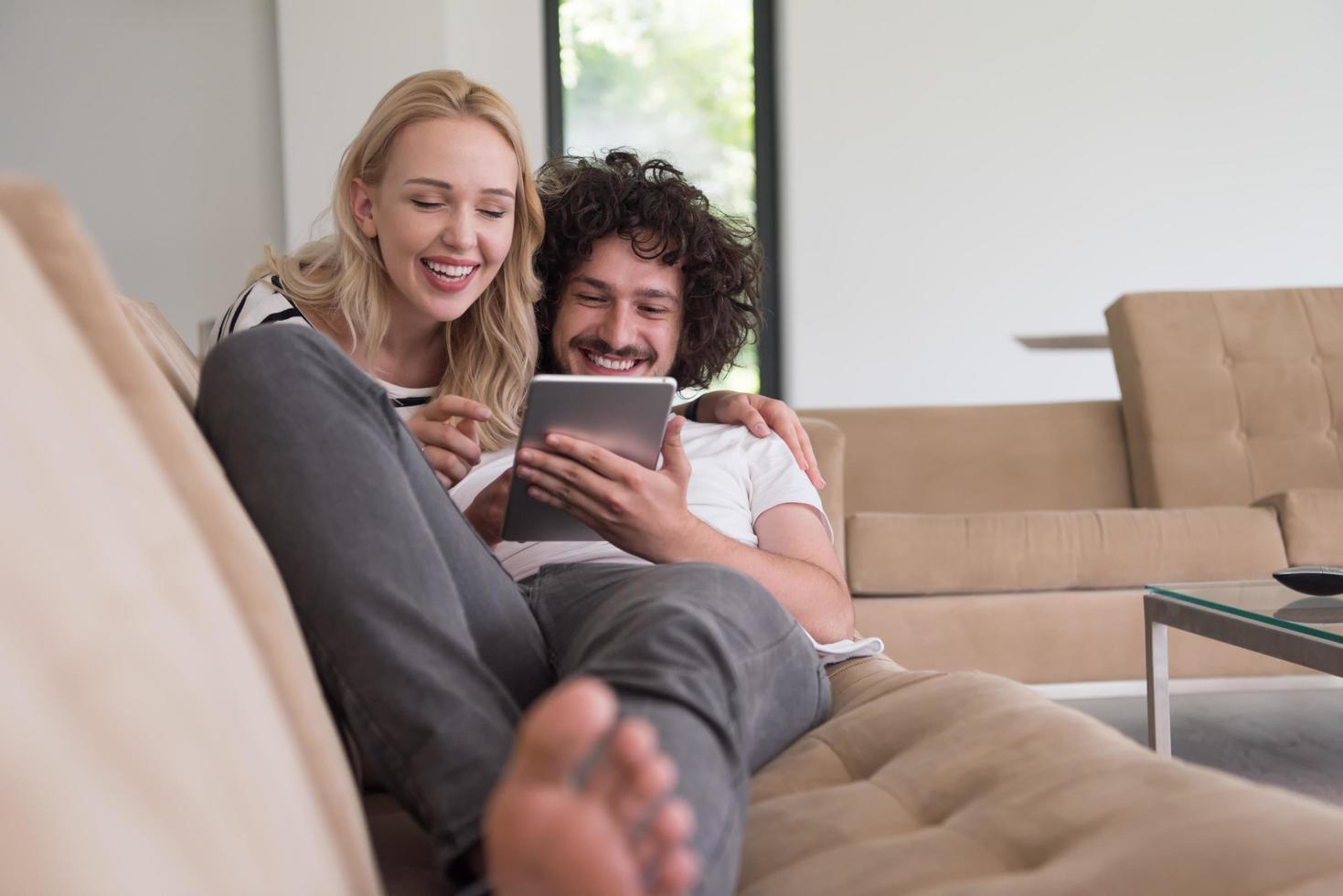 couple relaxing at  home with tablet computers photo