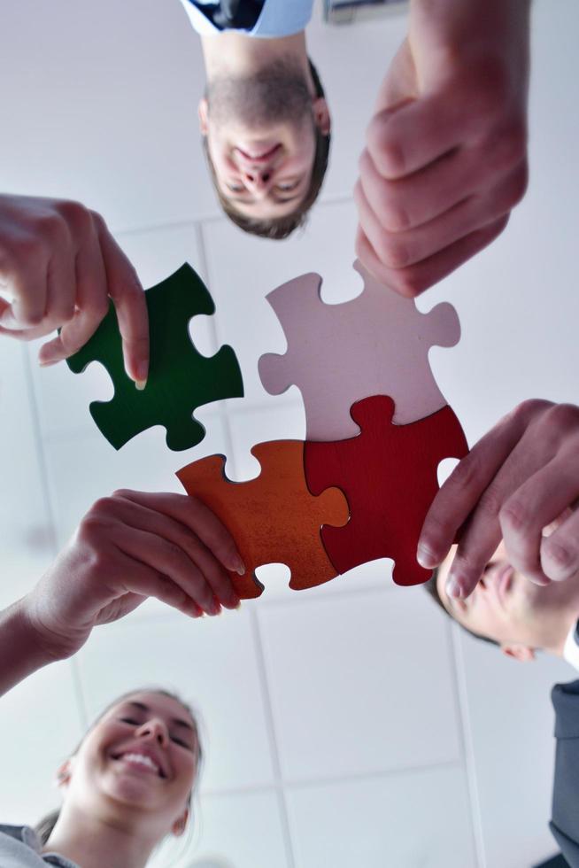 Group of business people assembling jigsaw puzzle photo